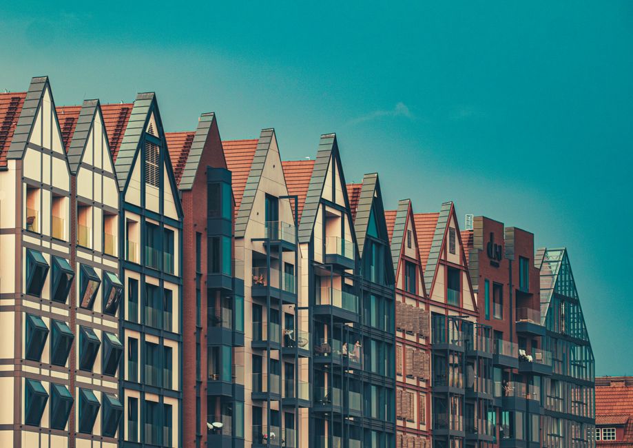 Stylish modern apartment buildings with sharp gabled roofs under a clear blue sky.