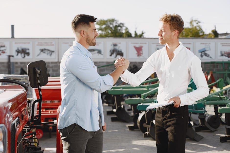 Two businessmen shaking hands outdoors, signaling a successful deal.